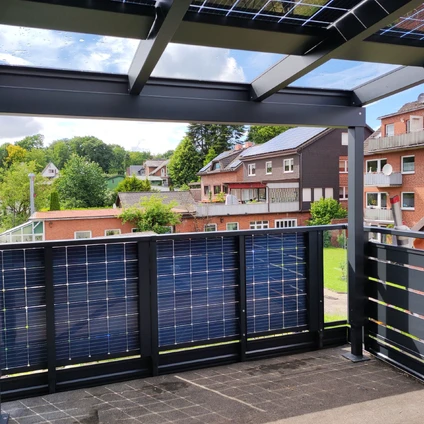 Solarpanel-Überdachung und -Wand auf einer Dachterrasse mit Blick auf Häuser und Bäume