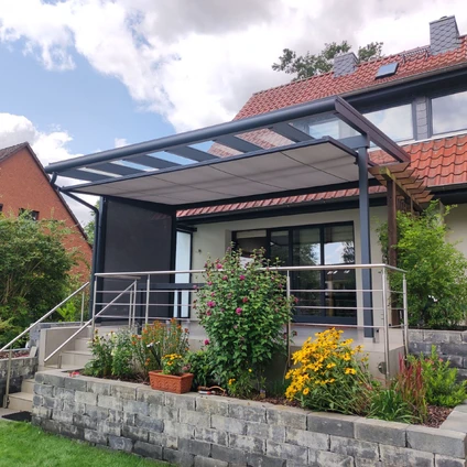 Modernes Haus mit gläsernem Anbau Treppe und blühendem Blumenbeet im Garten