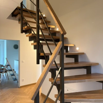 Minimalistische Holz-Stahl-Treppe mit beleuchteten Trittflächen und modernem schwarzen Geländer