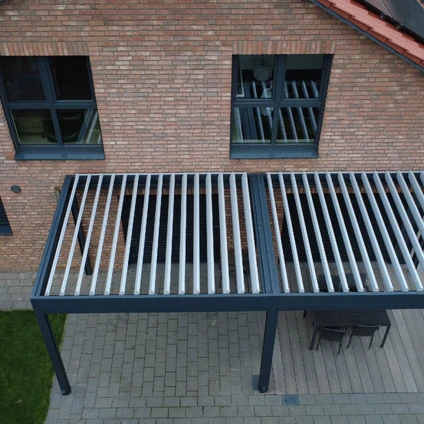 Metallener geriffelter Gartentisch vor einer Ziegelfassade mit zwei Fenstern