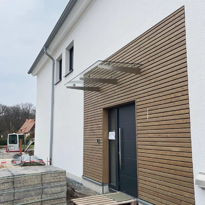 Neubau-Fassade Weißer Putz trifft auf Holzverkleidung in moderner kontrastreicher Architektur